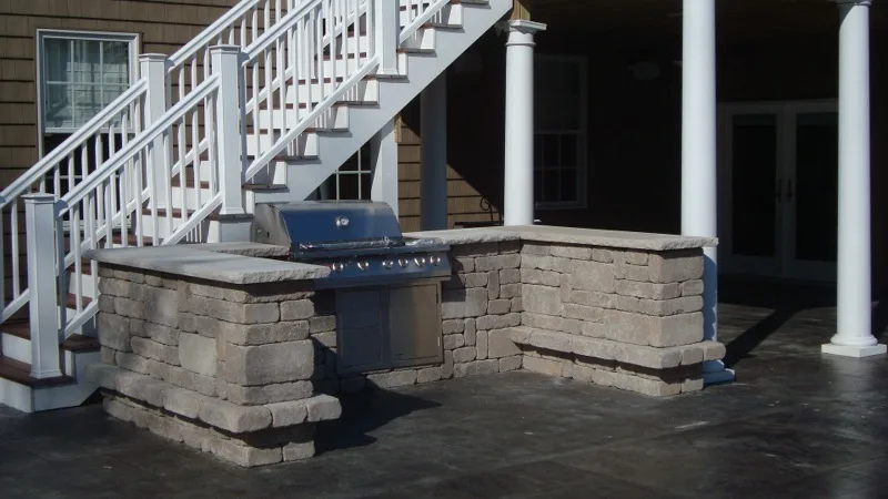 Built-in outdoor bar and grill unit with stone facade