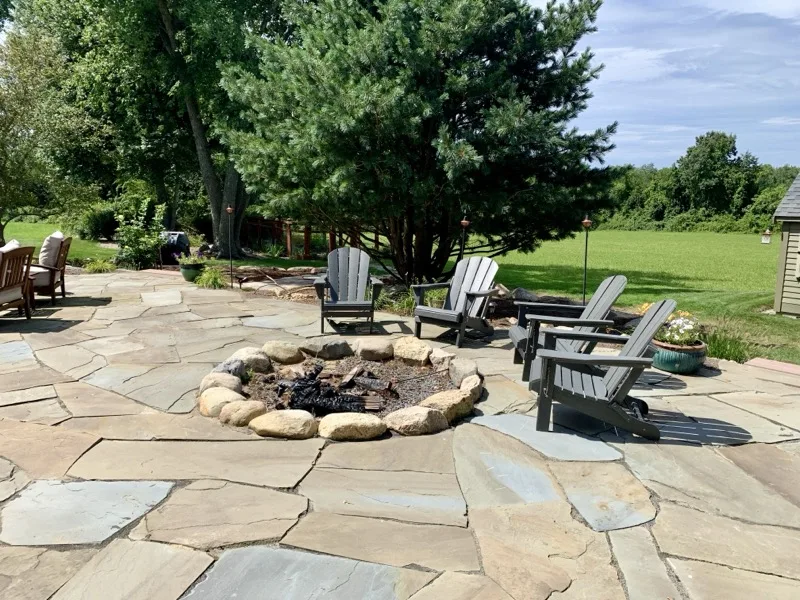 Stone fire pit lounge with Adirondack chairs