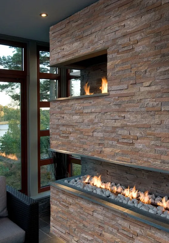 Modern ledger stone double fireplace overlooking the water